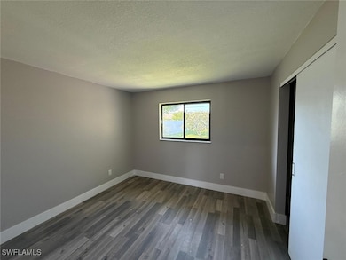 Unfurnished bedroom featuring dark wood-style floo