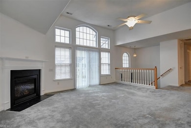 Spacious living area with soaring cathedral ceiling, gas fireplace and balcony.