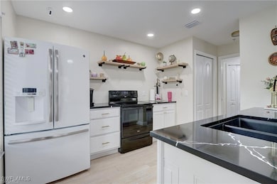 Kitchen featuring white fridge with ice dispenser,