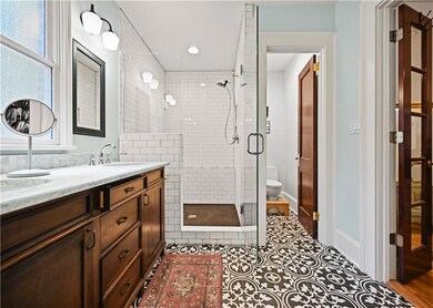 Full bathroom with a stall shower, vanity, and tile patterned floors