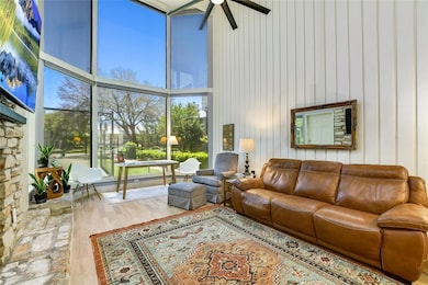 Living room with a high ceiling, ceiling fan, woo