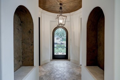 Entry with handsome stone flooring and art niches.