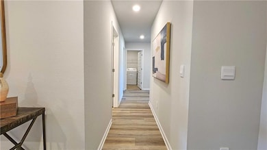 Hallway with washer / clothes dryer, light wood fi