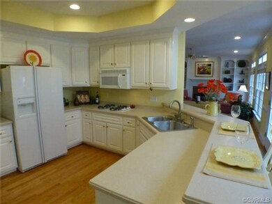Open kitchen has angled breakfast bar for quick me