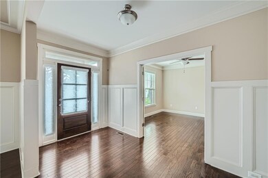 Entryway featuring a decorative wall, wainscoting,
