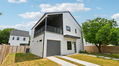 Contemporary home featuring board and batten siding, a fenced backyard, a balcony, and a garage