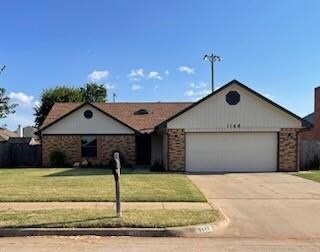 Ranch-style house featuring a garage and a front l