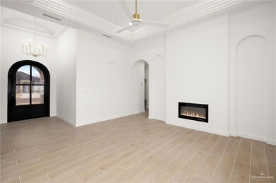 Foyer with ceiling fan with notable chandelier, light hardwood / wood-style floors, and a tray ceiling