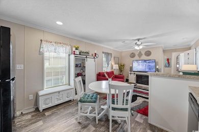 Dining space with ornamental molding, wood finished floors, a ceiling fan, a textured ceiling, and recessed lighting