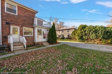 View of front facade featuring brick siding, entry steps, and a balcony