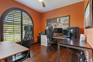 Office space featuring dark wood-style flooring and a ceiling fan