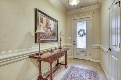 Foyer entrance featuring ornamental molding, light