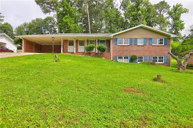 Single story home with concrete driveway, an attached carport, and a front yard