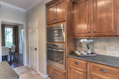 Warm wood cabinetry enhances the family friendly gourmet kitchen with stainless steel oven and microwave.