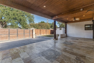 Fenced backyard featuring a patio, ceiling fan, and a storage unit