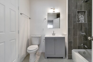 A new master full bath with modern grey tiles, whi