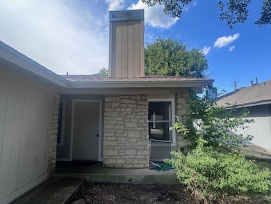 Entrance to property with stone siding and a chim