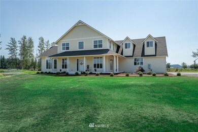 Second view of front of home with large nicely landscaped front yard wrap around convered deck and 4 car tandem garage for all your toys