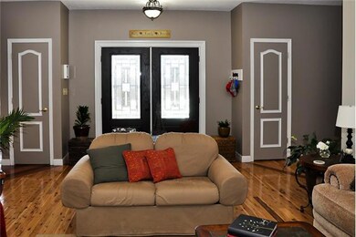 Double frosted and leaded glass doors open to a spacious foyer