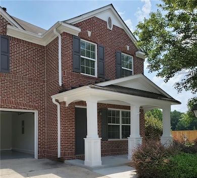 View of front of home with brick siding, a porch, concrete driveway, and a garage