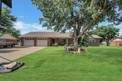 Ranch-style home with an attached garage, brick siding, a front lawn, and driveway