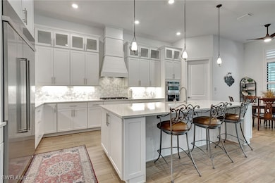 Kitchen featuring white cabinetry, custom exhaust