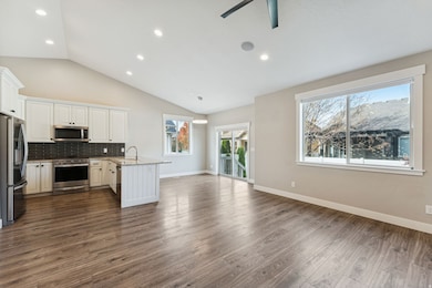 Kitchen featuring a peninsula, tasteful backsplash, appliances with stainless steel finishes, white cabinetry, and recessed lighting