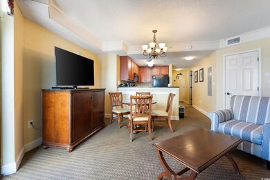 Living room with an inviting chandelier, light col