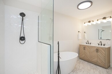 The primary bathroom features a shower and free-standing tub.