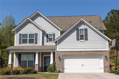 Craftsman house with driveway, covered porch, a garage, and brick siding