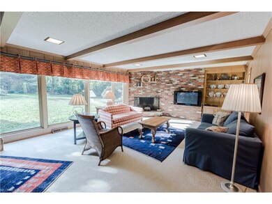 The paneled family room features a fireplace, beam
