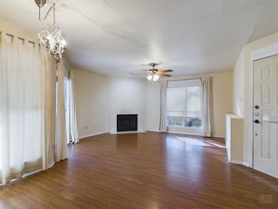Unfurnished living room featuring baseboards, dar
