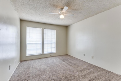 Carpeted spare room featuring a ceiling fan and a 