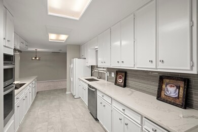 Modern kitchen with white cabinetry, stainless ste
