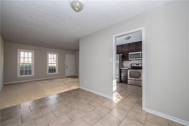 tiled entryway with carpeted living room floors an