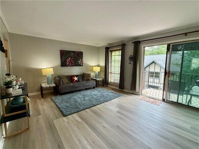 Living area with crown molding, wood finished floors, and baseboards