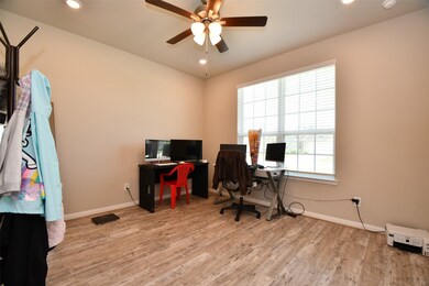 The home office features large windows, a ceiling