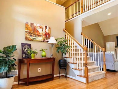 Stairway with wood finished floors, a high ceiling