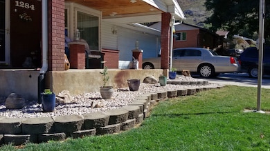 Covered porch with a garage and a yard