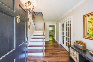 Foyer featuring a chandelier, crown molding, stair