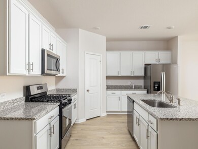 Kitchen featuring white cabinets, a sink, light w