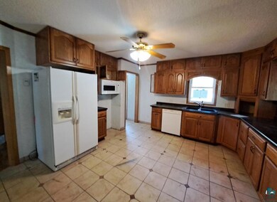 Kitchen featuring ceiling fan, sink, white applian