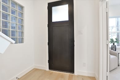 To your right, a bedroom awaits, enhanced by crisp white walls that add brightness and warmth to the space.