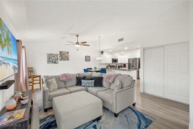 Living room with ceiling fan, a textured ceiling,