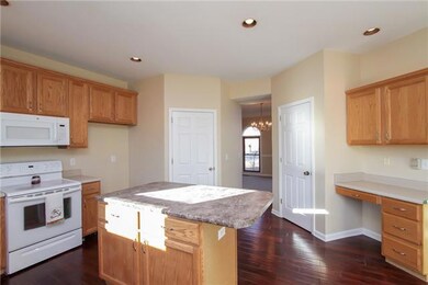 This kitchen features an island, tons of cabinets and a built in desk 