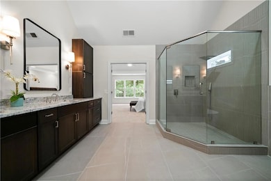 Bathroom with vanity, a stall shower, tile patterned flooring, and connected bathroom