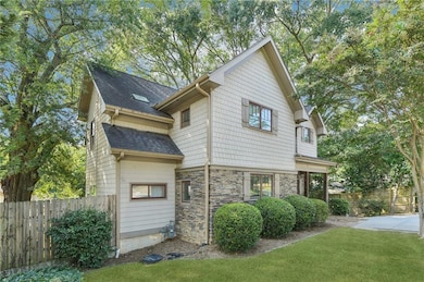View of home's exterior with roof with shingles and stone siding