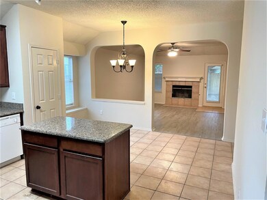 Kitchen with a fireplace, light hardwood / wood-style flooring, white dishwasher, and dark brown cabinets