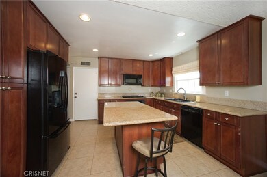 Kitchen pantry surrounds refrigerator and located adjacent family room