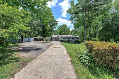 Ranch-style house featuring asphalt driveway